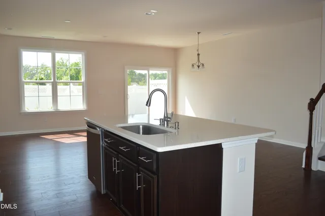 a kitchen with a sink a window and wooden floor