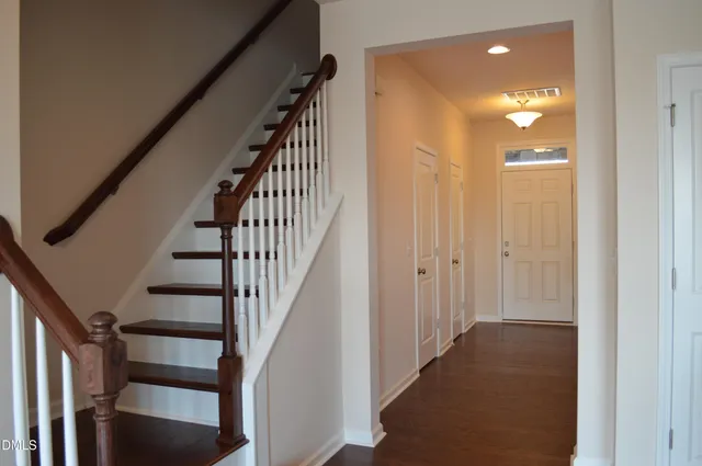 a view of a hallway with wooden floor and entryway