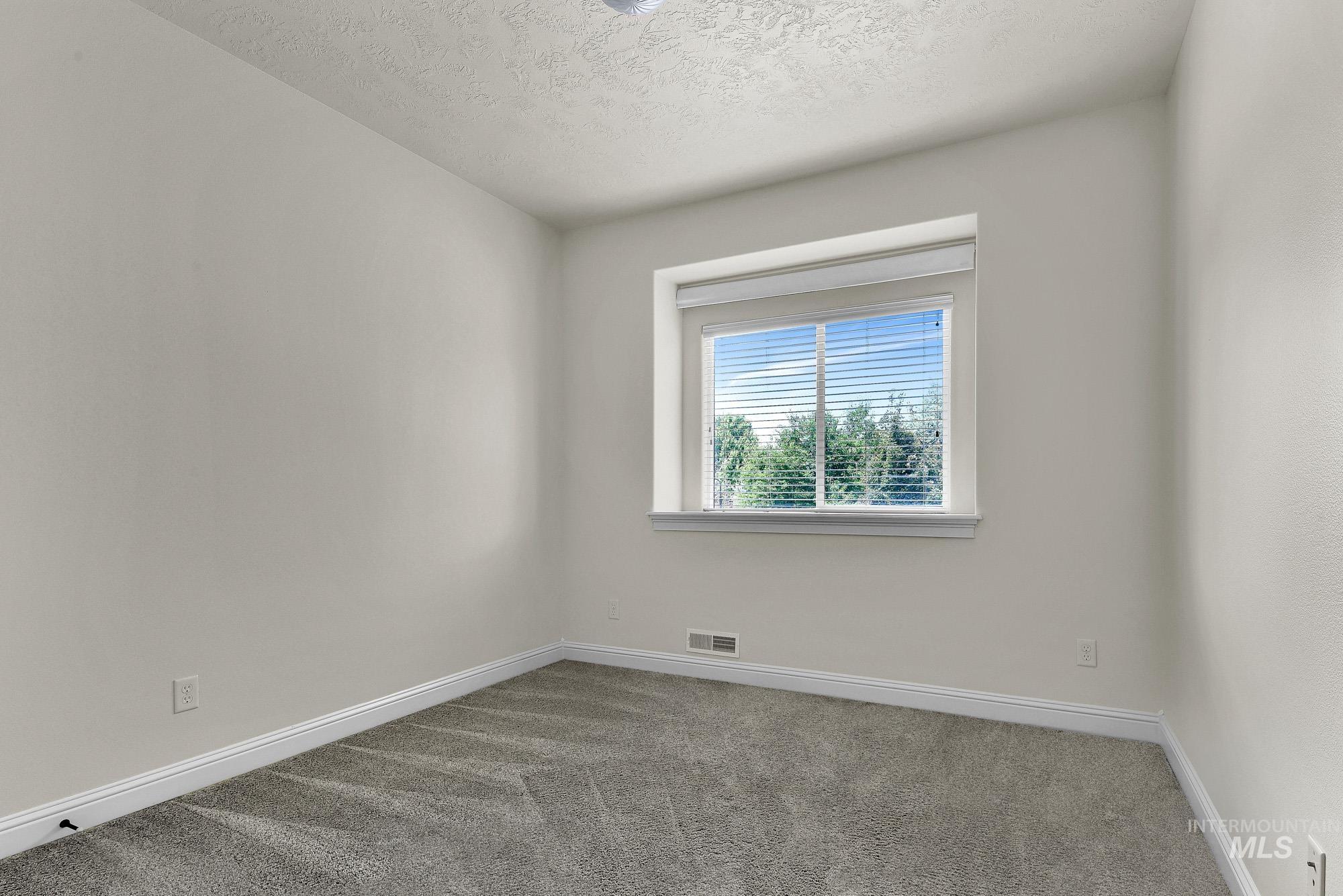 2172 West Cedar Grove Street Meridian, ID 83646 - Photo 23 of 49 Neutral-toned walls complement the gray patterned carpet, creating a versatile interior space