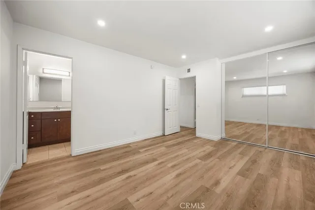 an empty room with wooden floor and bathroom