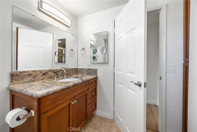 a bathroom with a granite countertop sink and a mirror