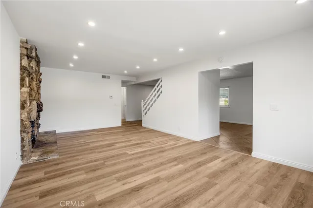 an empty room with wooden floor and entryway