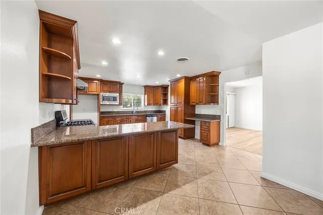 a kitchen with stainless steel appliances granite countertop a sink and cabinets