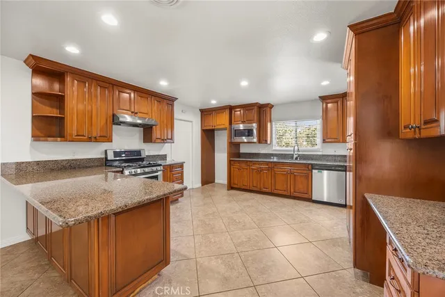 a kitchen with stainless steel appliances granite countertop a sink stove and refrigerator