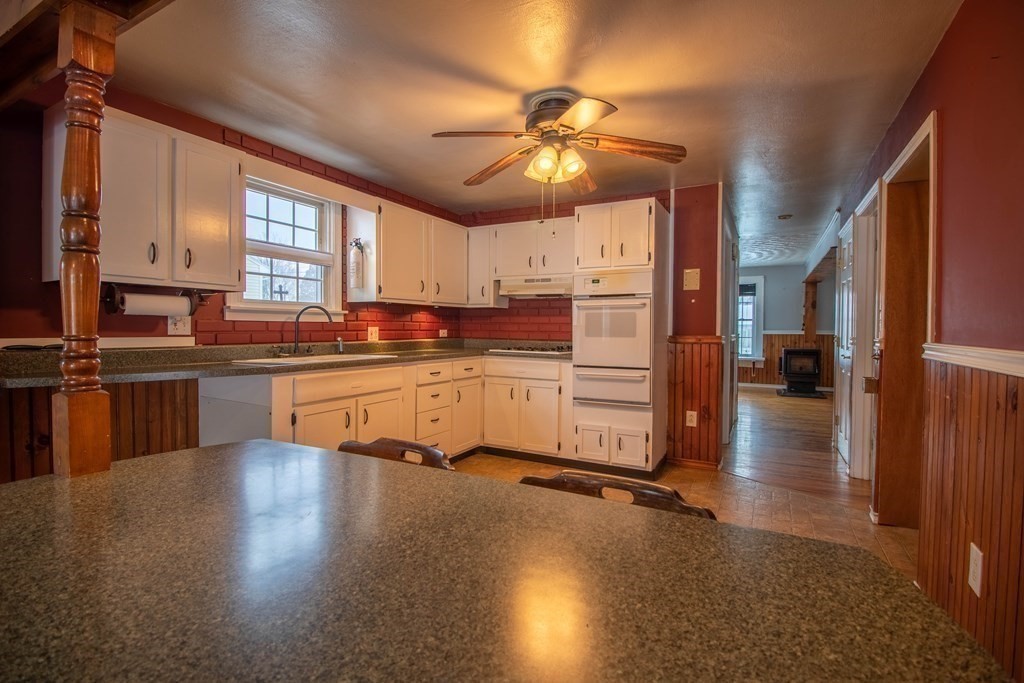 a kitchen with stainless steel appliances a center island cabinets and a wooden floor