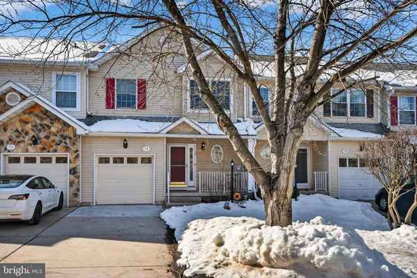 a front view of a house with a large tree