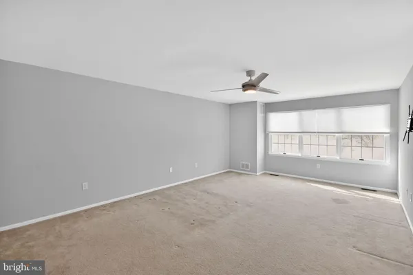 a view of an empty room with a ceiling fan