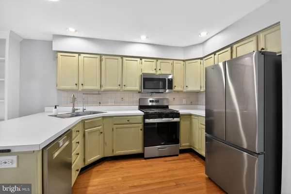 a kitchen with stainless steel appliances a refrigerator sink and microwave