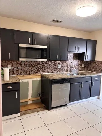 a metallic refrigerator freezer sitting in a kitchen