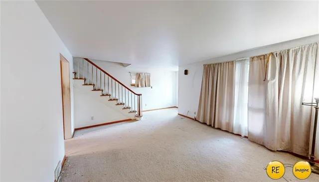 an empty room with a window and ceiling fan