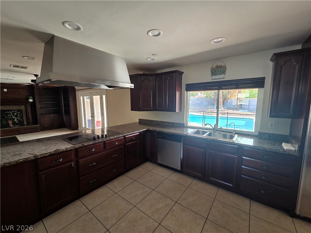 3381 Westwind Road Las Vegas, NV 89146 - Photo 29 of 52 Culinary haven with granite counters and rich cabinetry, offering direct views of the inviting pool.
