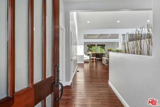 a hallway with wooden floor and furniture