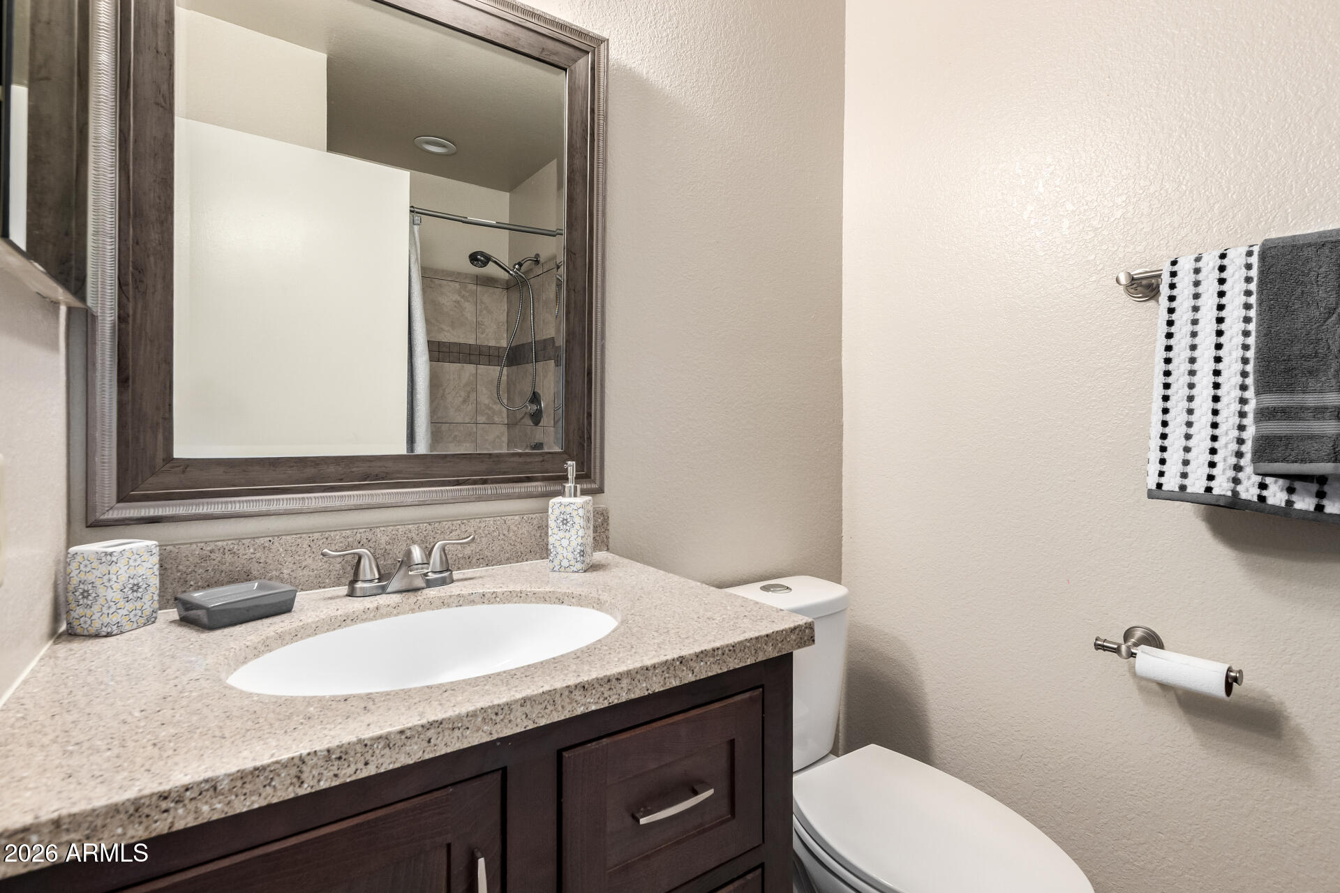 8111 West Wacker Road, Unit 13 Peoria, AZ 85381 - Photo 15 of 28 a bathroom with a granite countertop toilet sink and mirror