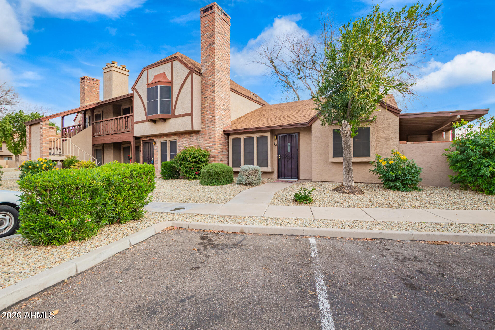 8111 West Wacker Road, Unit 13 Peoria, AZ 85381 - Photo 3 of 28 a front view of a house with a yard and potted plants