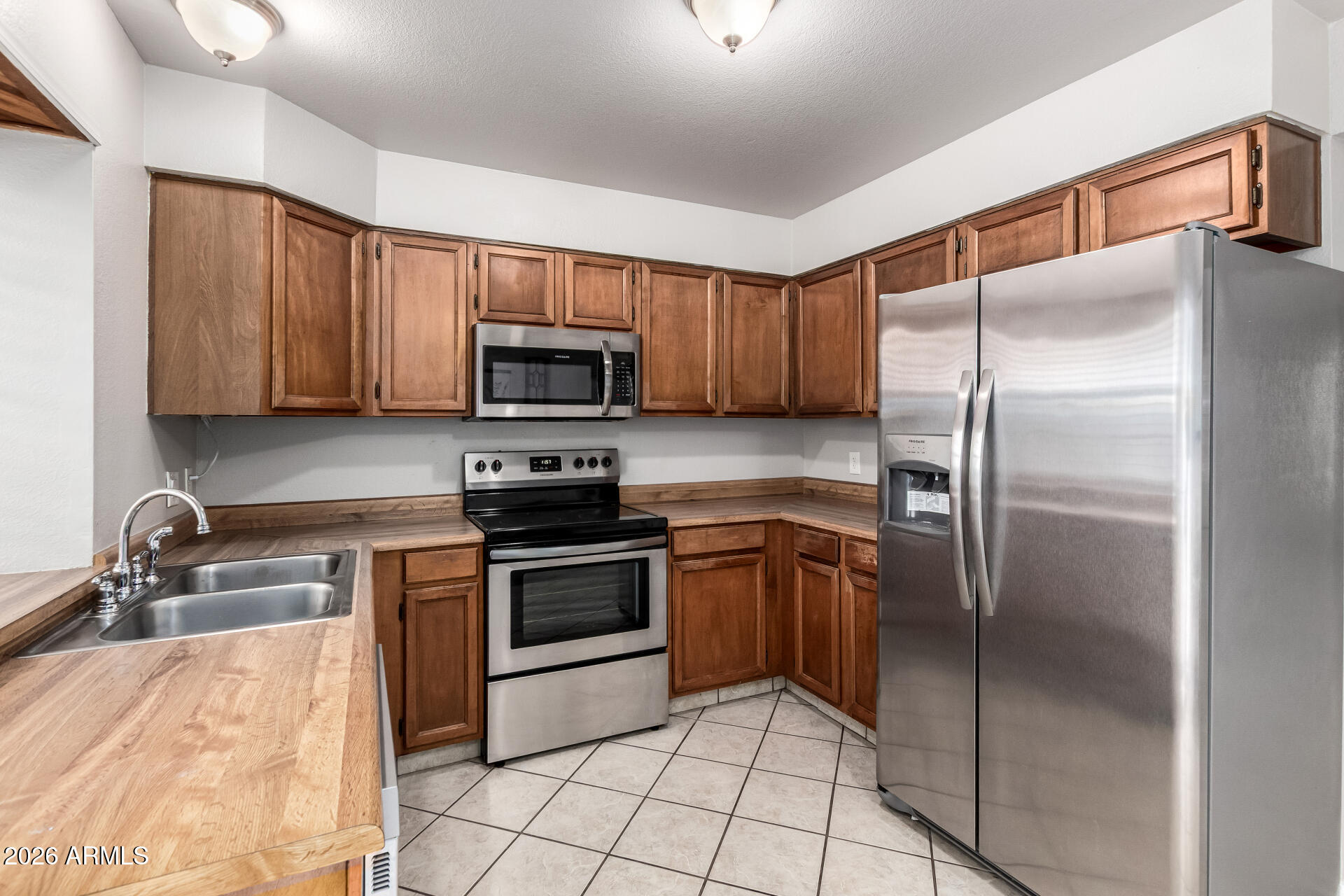 8111 West Wacker Road, Unit 13 Peoria, AZ 85381 - Photo 8 of 28 a kitchen with granite countertop a refrigerator and a sink