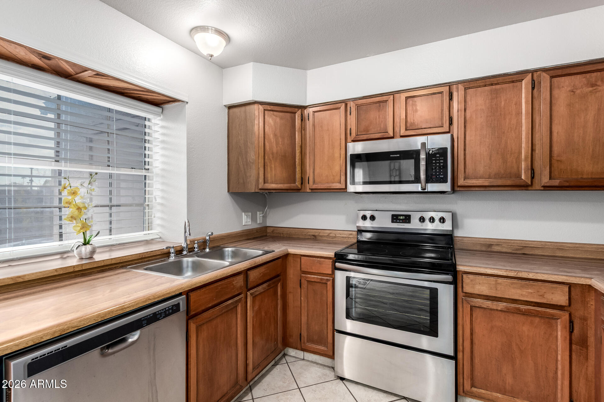 8111 West Wacker Road, Unit 13 Peoria, AZ 85381 - Photo 9 of 28 a kitchen with granite countertop a sink stove and microwave