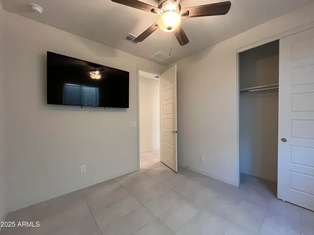 a view of an empty room with a ceiling fan