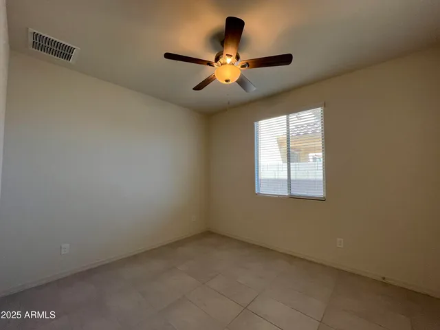 an empty room with window and a ceiling fan