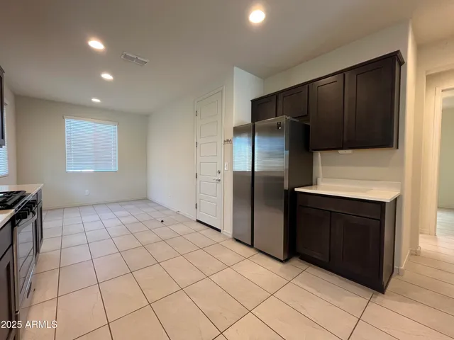 a kitchen with a refrigerator a stove and cabinets