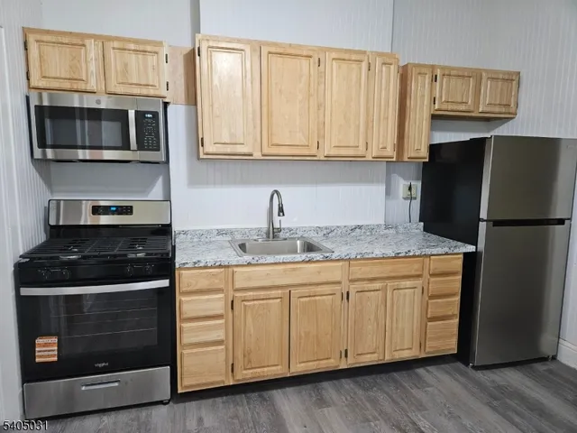 a kitchen with stainless steel appliances granite countertop a stove a microwave and a refrigerator