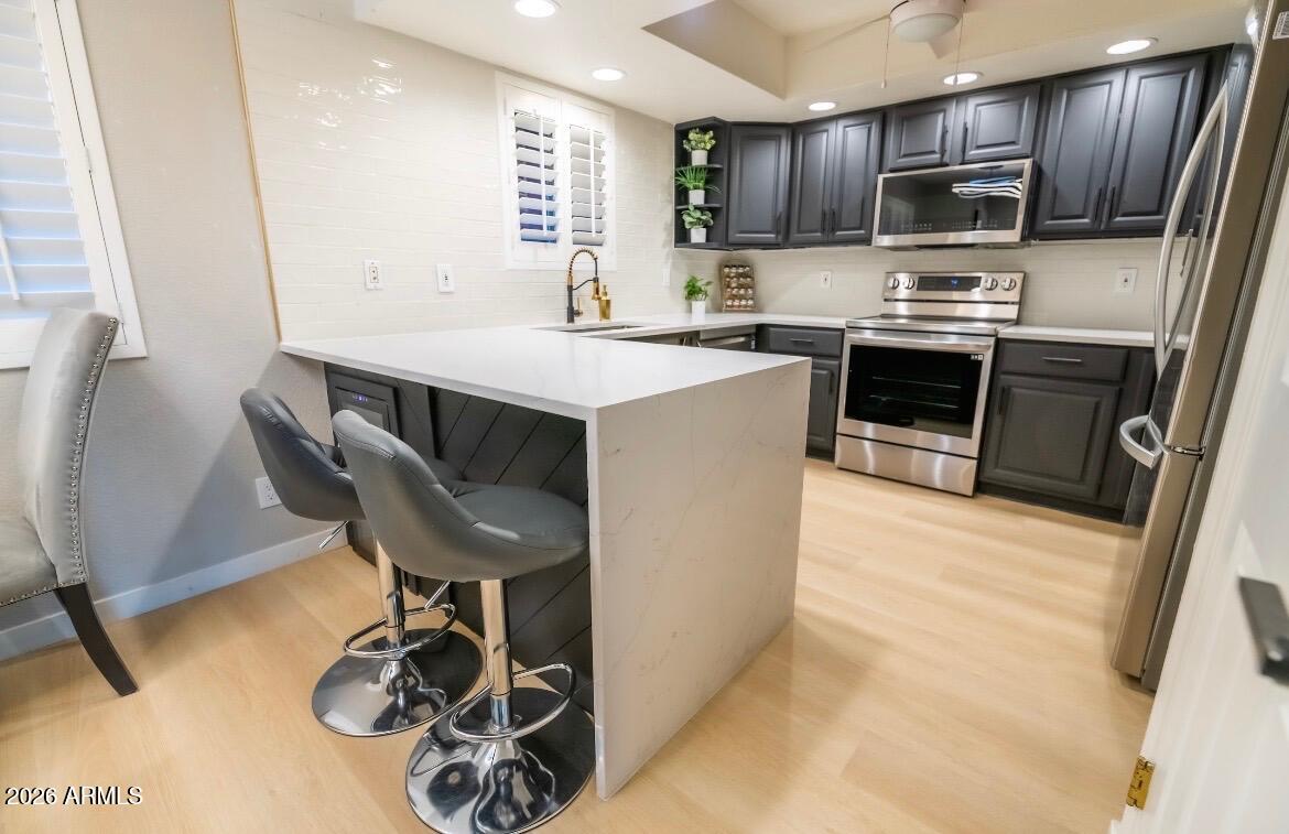 4303 East Cactus Road, Unit 128 Phoenix, AZ 85032 - Photo 15 of 39 a kitchen with kitchen island a large counter top appliances and cabinets