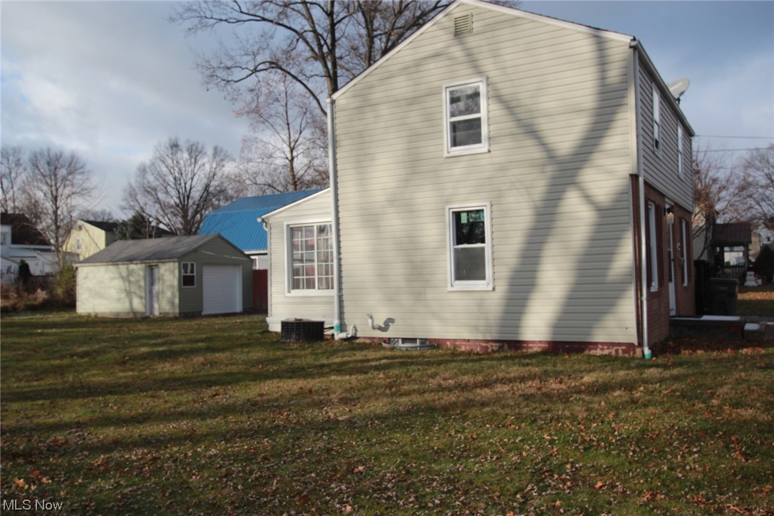 3606 Shelby Road Youngstown, OH 44511 - Photo 27 of 33 Back of property with central air condition unit, a lawn, and an outdoor structure