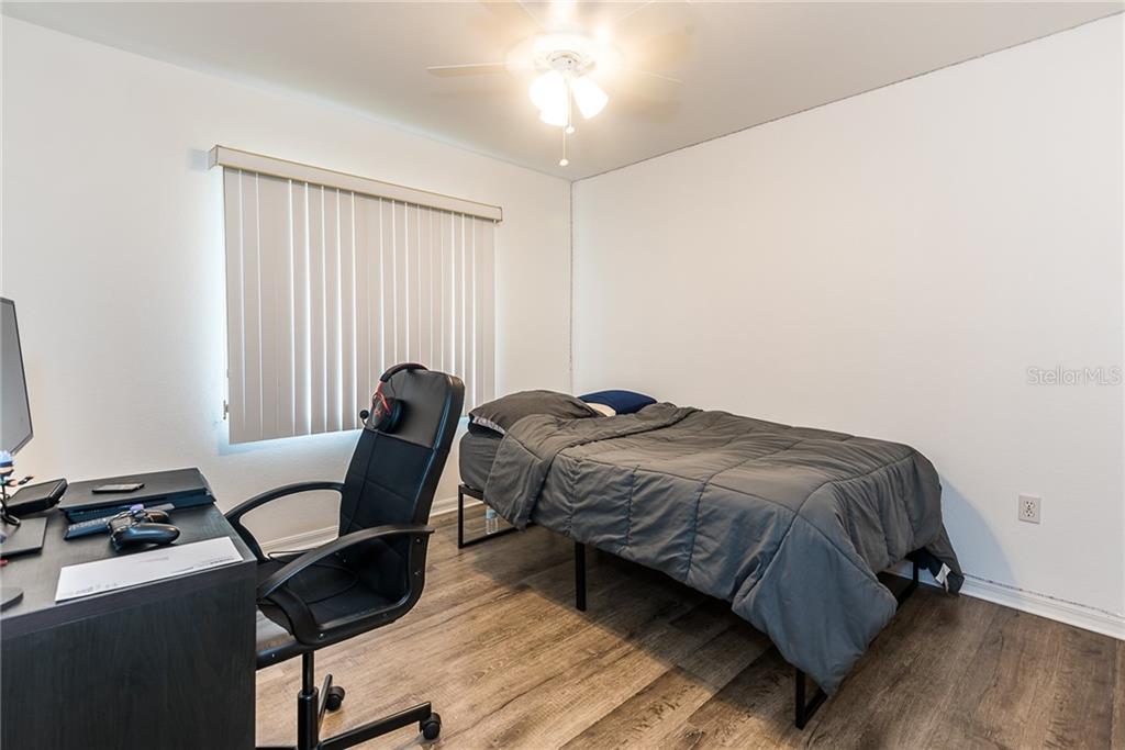 7557 South Blue Sage Punta Gorda, FL 33955 - Photo 17 of 28 a bedroom with a bed chair and a window