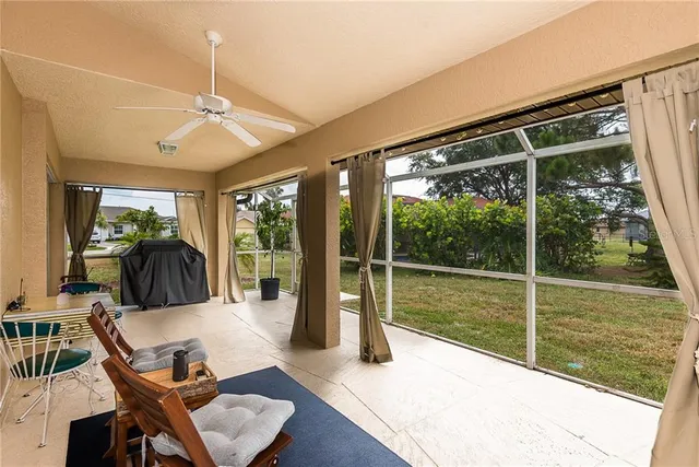 a living room with patio furniture and a floor to ceiling window