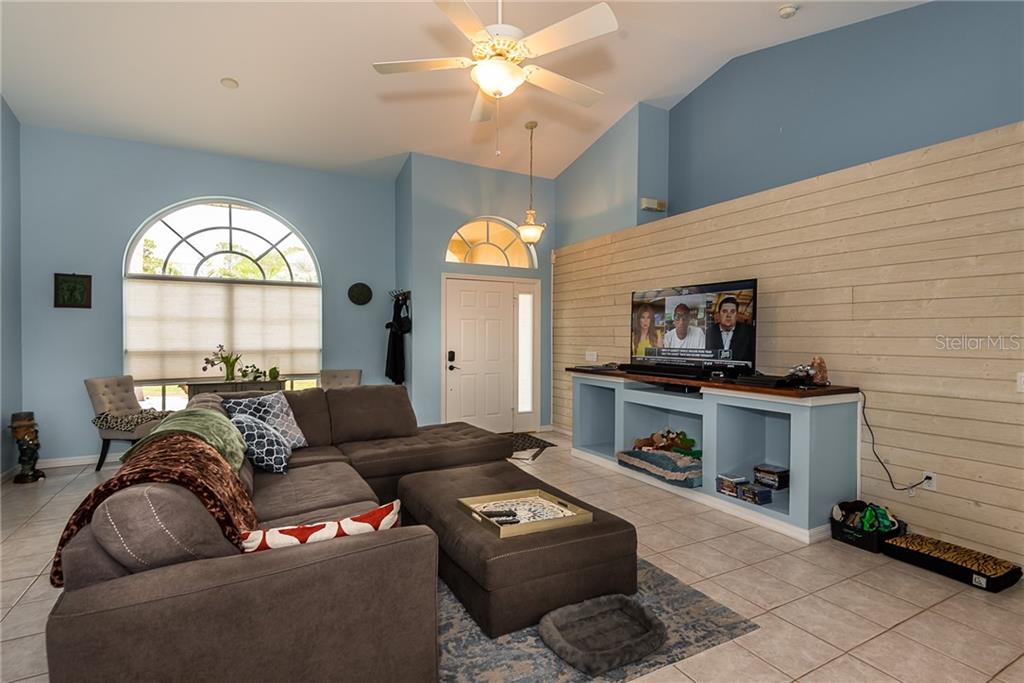 7557 South Blue Sage Punta Gorda, FL 33955 - Photo 4 of 28 a living room with furniture a large window and a fireplace
