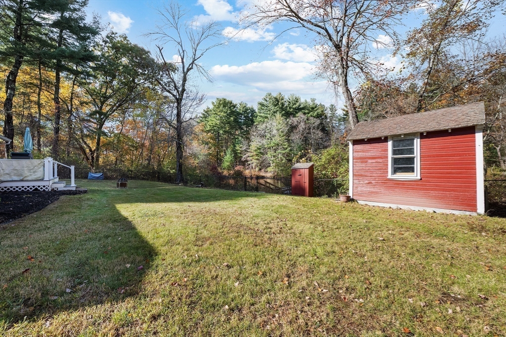 48 River Road Norfolk, MA 02056 - Photo 41 of 42 a backyard of a house with large trees and plants