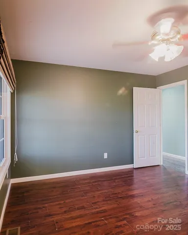 a view of a room with wooden floor and a window