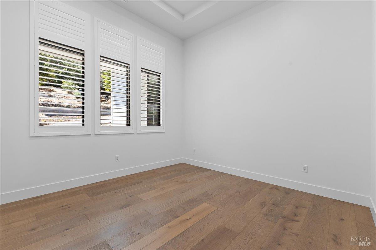 794 Los Olivos Road Santa Rosa, CA 95404 - Photo 13 of 59 an empty room with wooden floor and windows