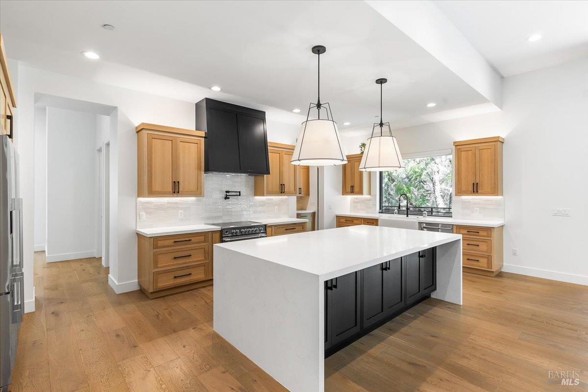 794 Los Olivos Road Santa Rosa, CA 95404 - Photo 21 of 59 a large kitchen with kitchen island a stove a sink a center island and wooden floor