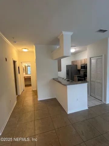 a large white kitchen with a sink and refrigerator