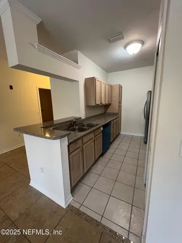 a kitchen with a sink a stove top oven and cabinetry