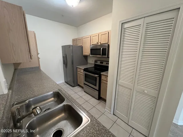 a kitchen with stainless steel appliances a refrigerator and a sink