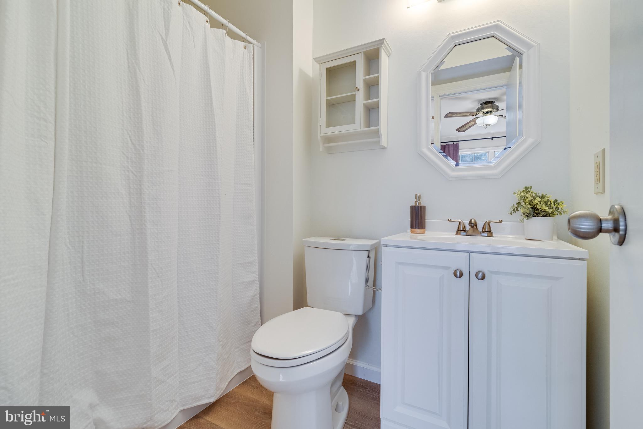5131 Solomons Island Road Huntingtown, MD 20639 - Photo 32 of 42 a bathroom with a sink vanity mirror and toilet