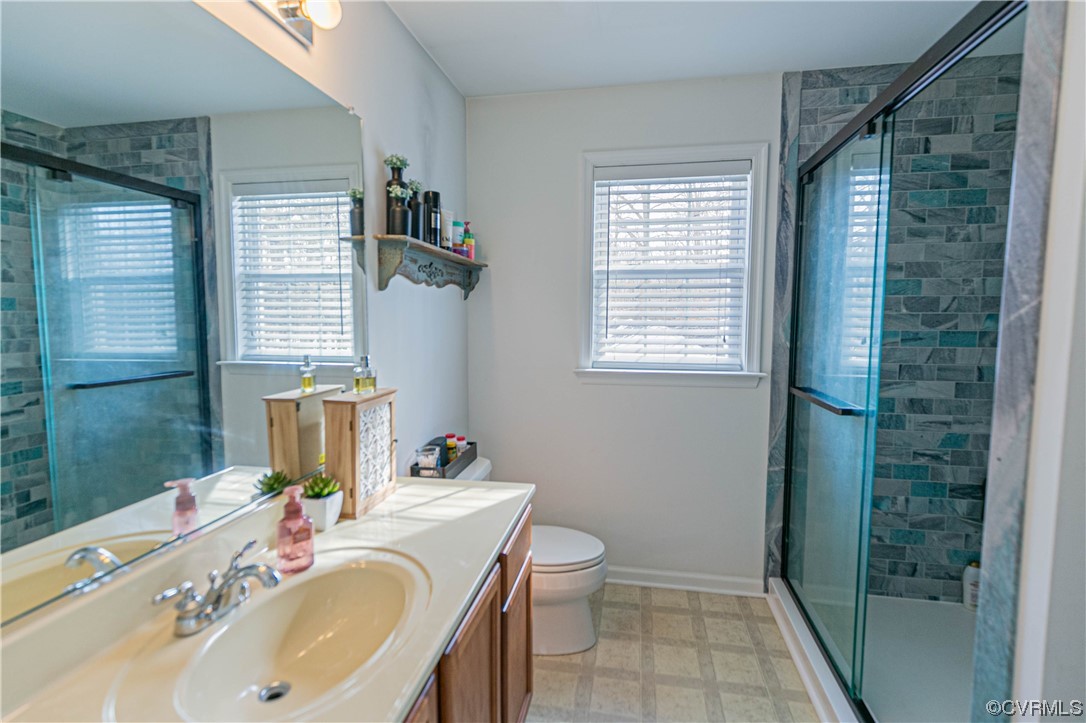 213 Cedar Ridge Drive Ruther Glen, VA 22546 - Photo 16 of 50 a bathroom with a granite countertop sink toilet a mirror and shower