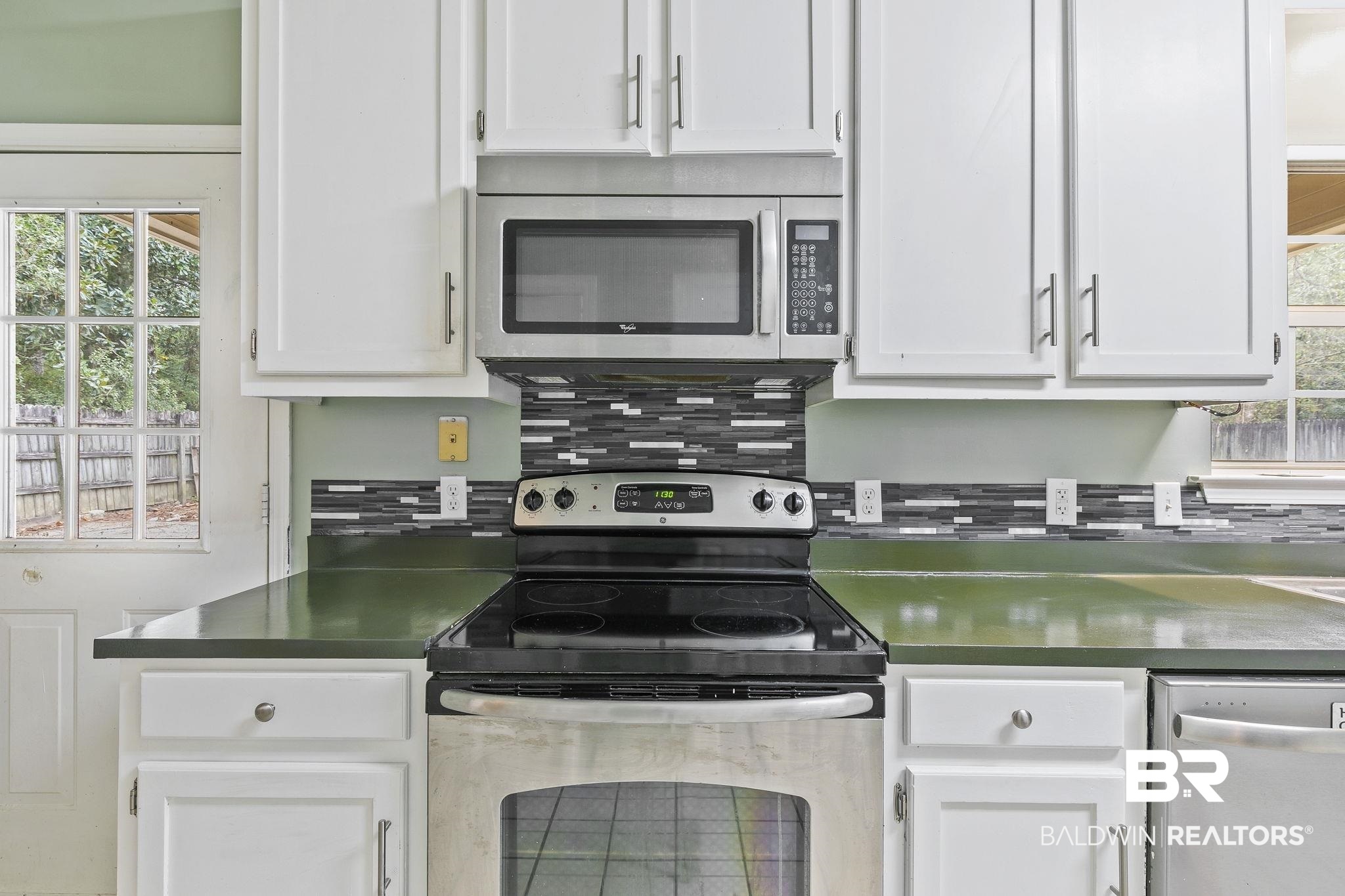 474 Ridgewood Drive Daphne, AL 36526 - Photo 23 of 57 Kitchen with white cabinets, tasteful backsplash, and stainless steel appliances
