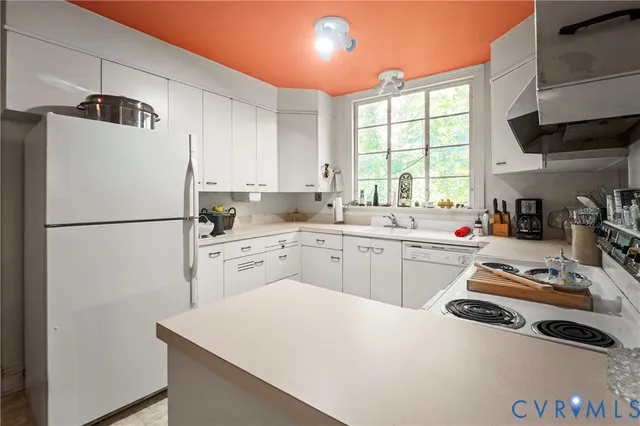 a kitchen with a refrigerator a sink and cabinets