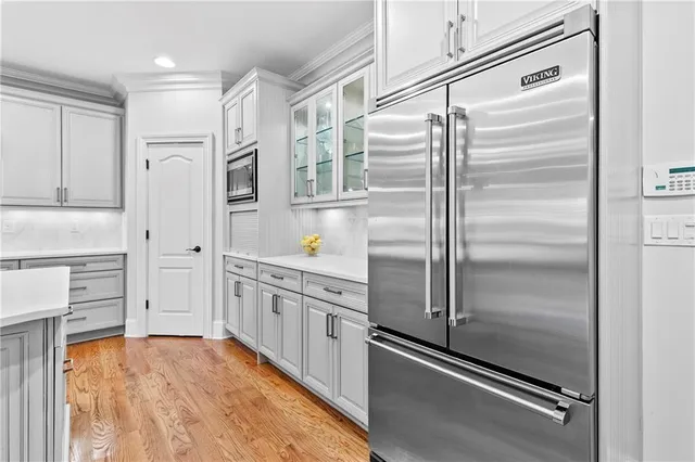 a kitchen with white cabinets and refrigerator