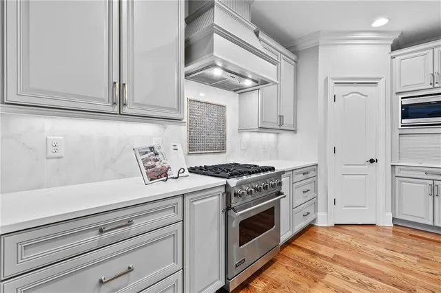 a kitchen with white cabinets and appliances