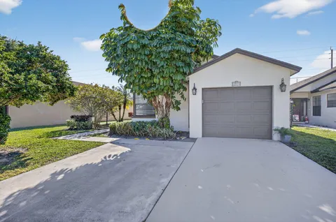 front view of a house with a yard and a garage