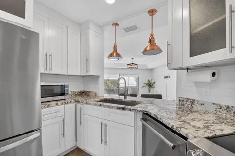 a kitchen with white cabinets and appliances