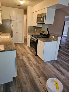 a kitchen with stainless steel appliances granite countertop a stove a sink and a refrigerator