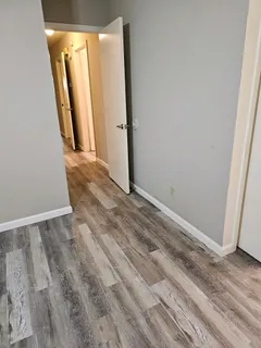 an empty room with wooden floor and a window