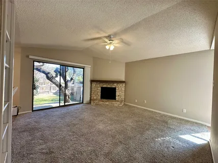 an empty room with windows and a fireplace