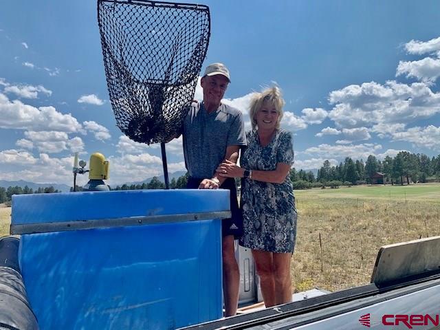5 Cottontail Lane Ridgway, CO 81432 - Photo 21 of 32 Deb and Randy Collins stocking the pond on the first hole...flyfish for trout on the first hole!