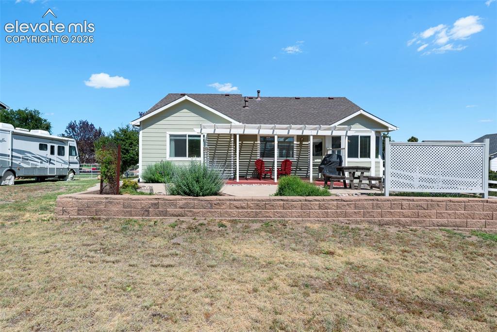 7840 Midnight Road Peyton, CO 80831 - Photo 41 of 48 Enjoy sunsets and the expanse of the backyard from this delightful patio with wind breaks and a pergola