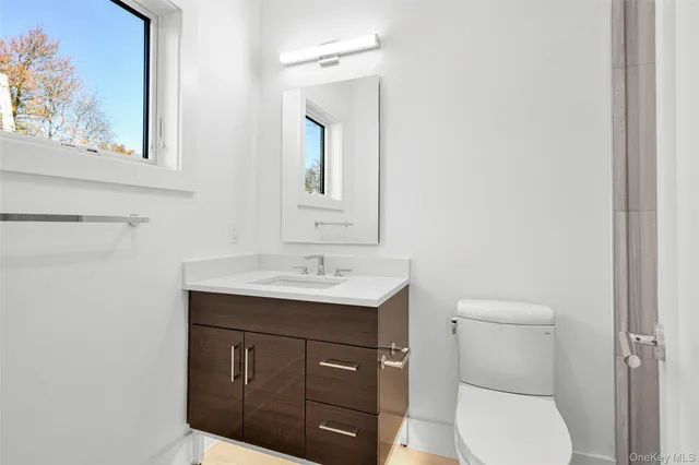 a bathroom with a toilet a sink and mirror